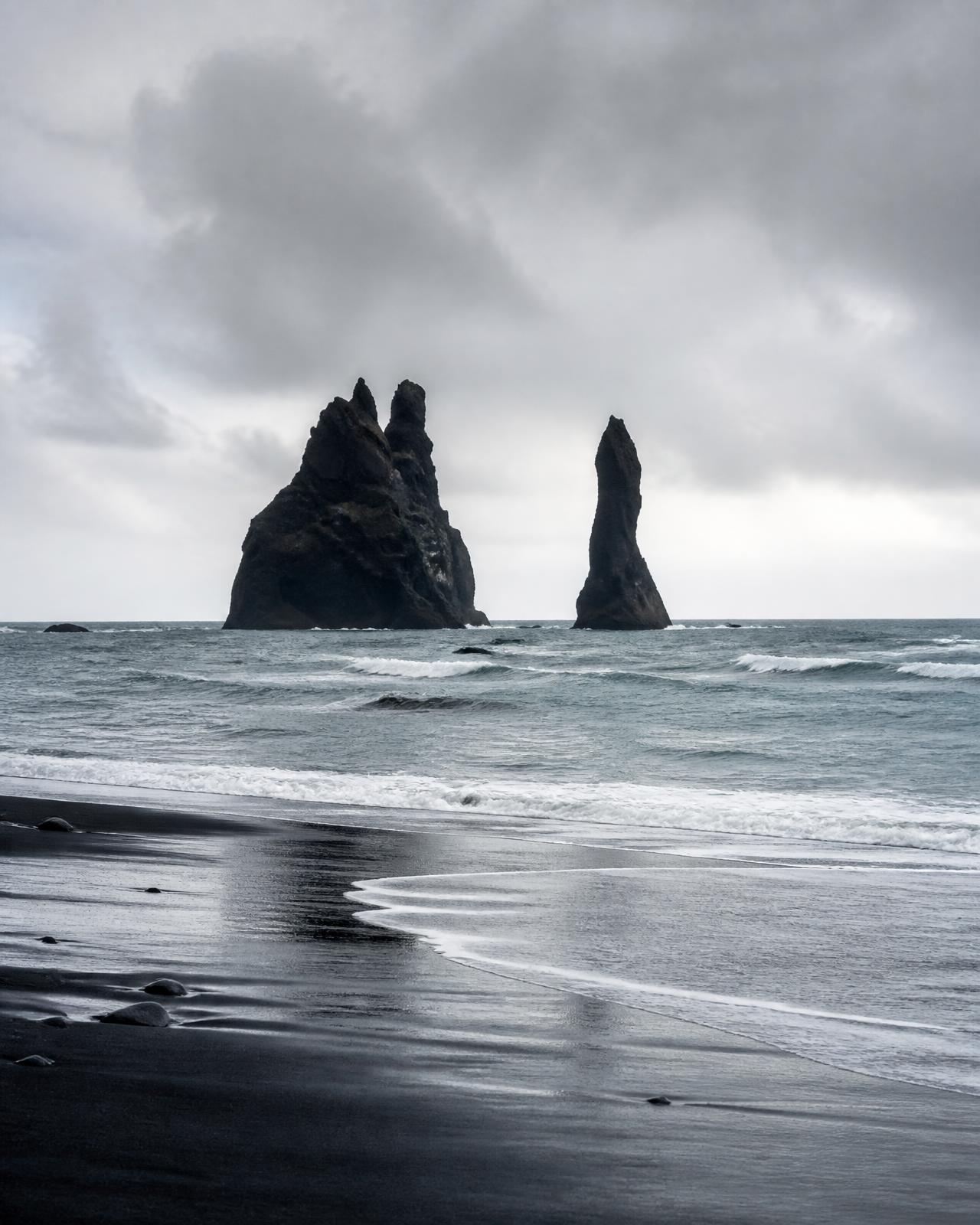 Basalt sea stacks off a black sand beach under cold Nordic light